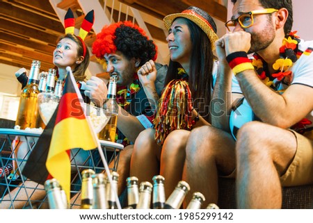 German soccer fans watch a soccer game at home and celebrate a victory