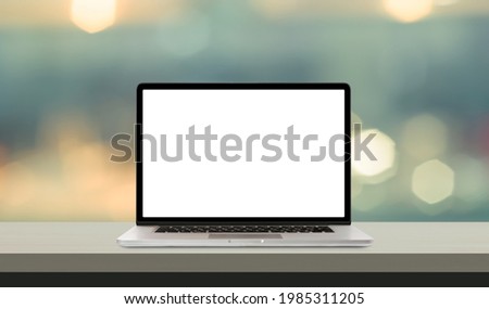 Laptop or notebook with blank screen on wood table in blurry background  Royalty-Free Stock Photo #1985311205