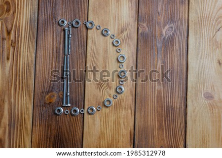 letters D of english alfabet made from bolts, screws and nuts on the wooden background
