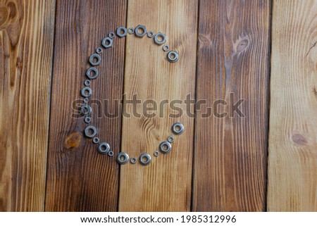 letters C of english alfabet made from bolts, screws and nuts on the wooden background