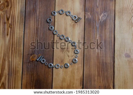 letters of english alfabet made from bolts, screws and nuts on the wooden background