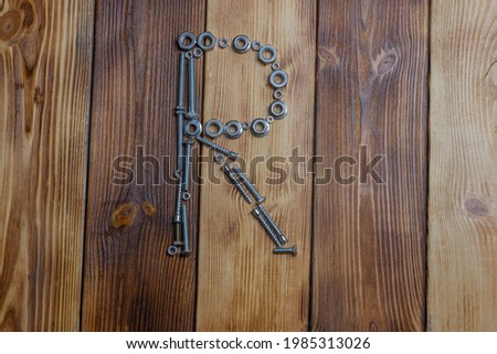 letters K of english alfabet made from bolts, screws and nuts on the wooden background