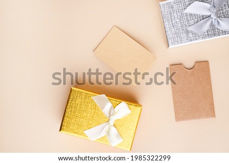 Business card mockup, eco kraft paper on a beige background and gift box for the holiday. Eco friendly stationery concept. Recyclable. High quality photo. Copy space. Vertical