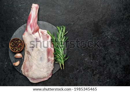 raw lamb shoulder blade with rosemary on stone background with copy space for your text Royalty-Free Stock Photo #1985345465