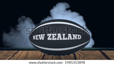 Compostion of rugby ball with text new zealand on black background with white smoke. championships, sports and competition concept digitally generated image.