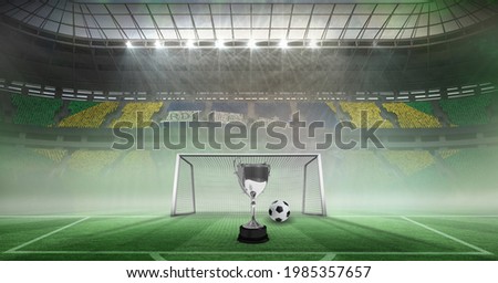 Compostion of cup and football over stadium and goal. championships, sports and competition concept digitally generated image.