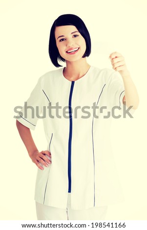 Woman doctor or nurse holding blank business card in her hand