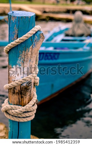 A blue boat sitting on top of a wooden fence
