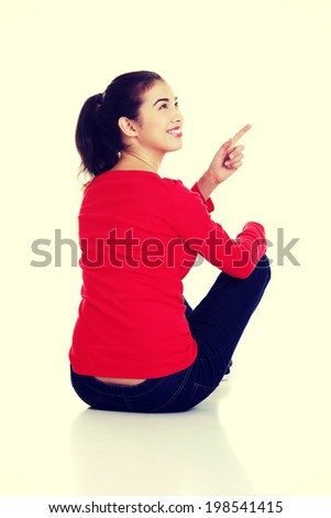 Happy young woman pointing on copy space
