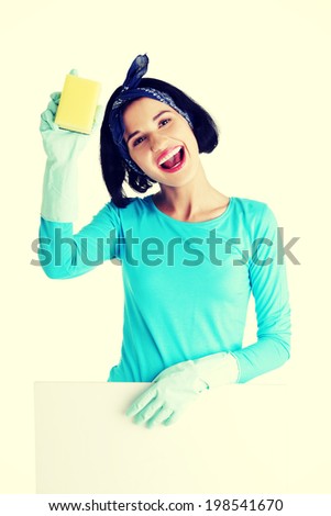 Smiling happy cleaning woman showing blank sign board.