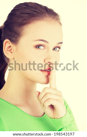 Hush be quiet woman. Teen girl with finger on her lips.