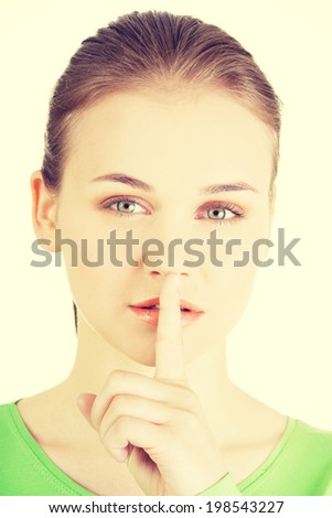 Hush be quiet woman. Teen girl with finger on her lips.