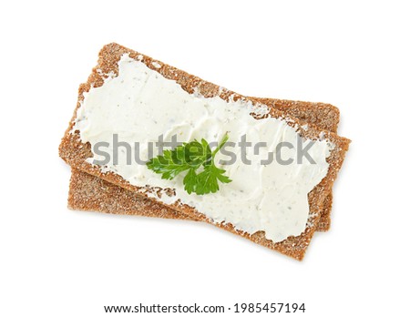 Fresh rye crispbreads with cream cheese and parsley on white background, top view Royalty-Free Stock Photo #1985457194