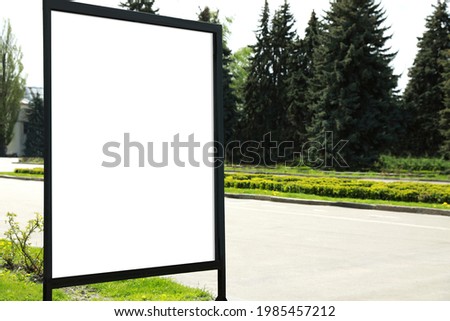 Blank advertising board on sidewalk in city. Mockup for design
