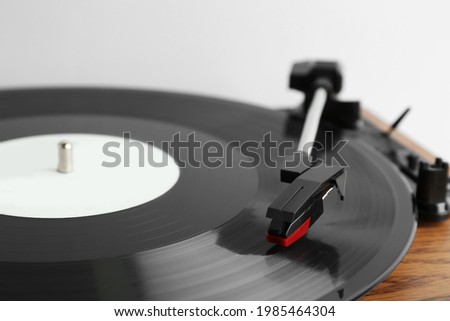 Vinyl record on turntable against light background, closeup