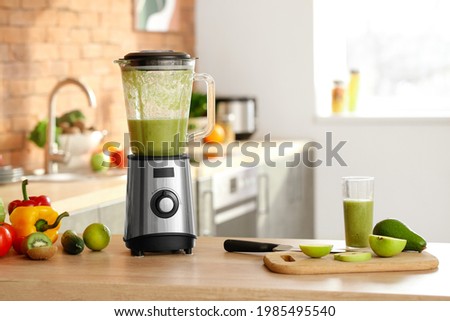 Blender and ingredients for smoothie on kitchen table Royalty-Free Stock Photo #1985495540