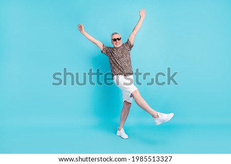 Full length photo of cheerful happy old man raise hands positive mood isolated on pastel blue color background