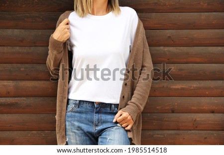 Girl wearing blank t shirt with denim and cardigan. Rustic white shirt mock up Royalty-Free Stock Photo #1985514518