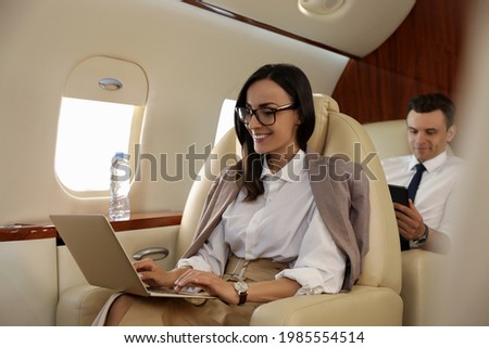 Businesswoman working on laptop in airplane during flight Royalty-Free Stock Photo #1985554514