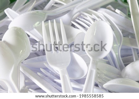 Lots of white plastic forks and spoons. Royalty-Free Stock Photo #1985558585