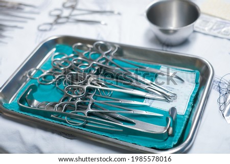 sterile surgical instruments are on a table during an operation. Medical instruments in a steel tray. Royalty-Free Stock Photo #1985578016