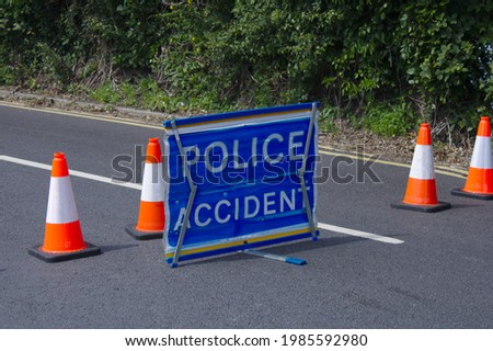 Police accident sign in the road with orange and white bollards