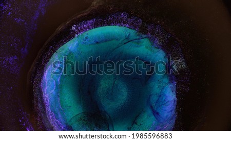 Abstract neon glow and blurry rays of light around the center of the circle. Purple blue and green picture