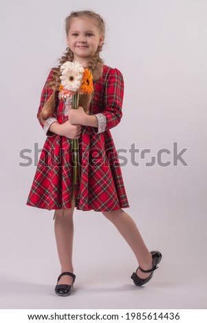 beautiful blonde girl with pigtails plaid dress school dress with gerberas flowers in her hands