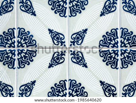 Portuguese ceramic tiles in detail, glazed and hand painted tile pattern in shades of blue on a light gray and white background, circular ornamental motifs.Tiled template, standard or model concept. 