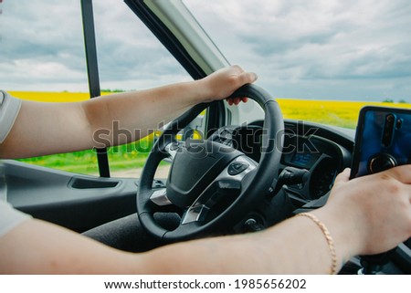 concept of a truck driver, driver's hands on the steering wheel on a sunny day in summer.