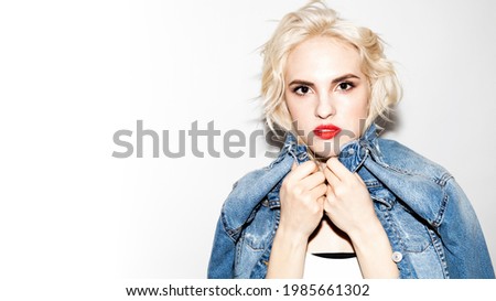 young blonde girl in a white T-shirt and denim jacket on a white background, studio fashion photo, copy space