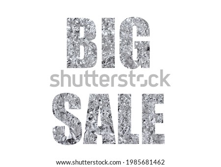 Gray metallic texture of crumpled aluminum foil. Shot through the cut-out silhouette of the word BIG SALE