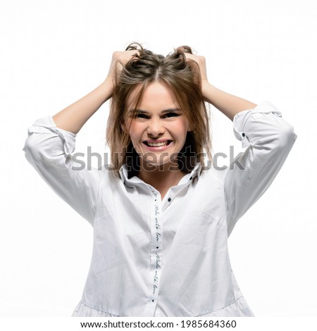 Problems, headache, stress and depression concept. Angry woman rips her hair. Isolated on white wall