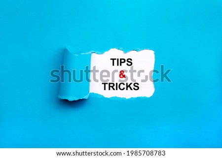 Tips and tricks symbol. Words 'Tips and tricks' appearing behind torn blue paper. Business, Tips and tricks concept. Copy space.