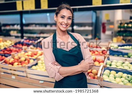 Portrait of beautiful smiling worker in grocery store. Royalty-Free Stock Photo #1985721368