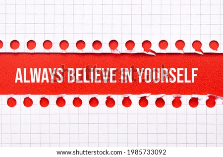 Business and law concept. Between two sheets of notebook on a red background the inscription - Always believe in yourself