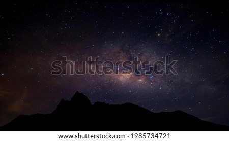 Milky Way. Night sky with stars and silhouette of Mountain Space background.Universe filled with stars, nebula and galaxy with noise and grain.Photo by long exposure and select white balance. 