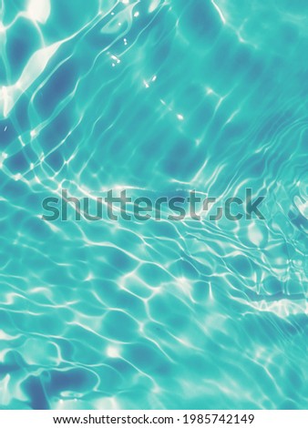 Closeup blue water splashed in the sea. Abstract of surface blue water for graphic design. Reflection on surface blue water in the swimming pool for background. Wave of blue water in the deep sea.