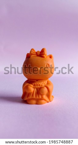 Photo of cute little doll replica on pink background