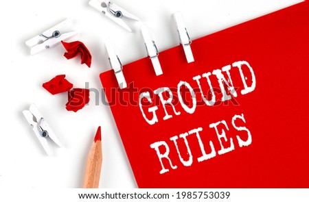 GROUND RULES text on red paper with office tools on white background