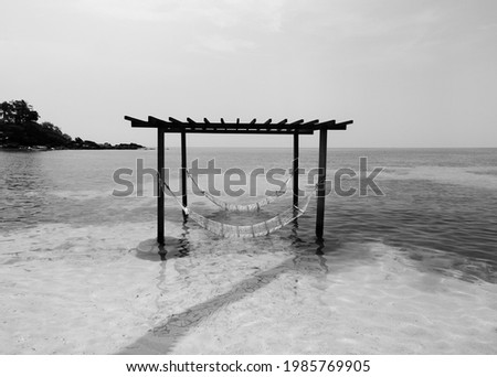 Serene peaceful sea on tropical island beach with gazebo and hammocks in summer. Koh Kood - Thailand - Black and white