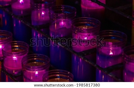 A picture of rows of lit candles on display in the Santa Maria de Montserrat Abbey.
