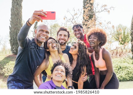 Group of runners taking a selfie in a park. Happy and smiling.