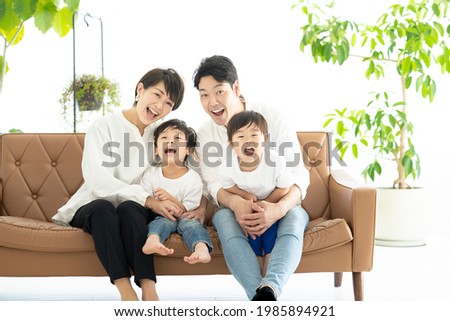 Family frolicking on the couch  Royalty-Free Stock Photo #1985894921