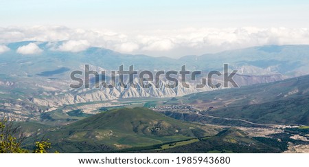 View of green mountains and villages in the valley. Wide angle panorama
