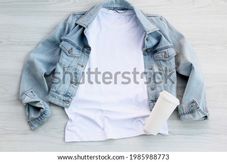 White cotton T shirt mockup with denim jacket, coffee cup on wooden floor. Design t shirt template, tee print presentation mock up