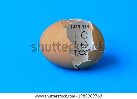 A cracked eggshell  with an escape plan drawn inside as a symbol of freedom Royalty-Free Stock Photo #1985989763
