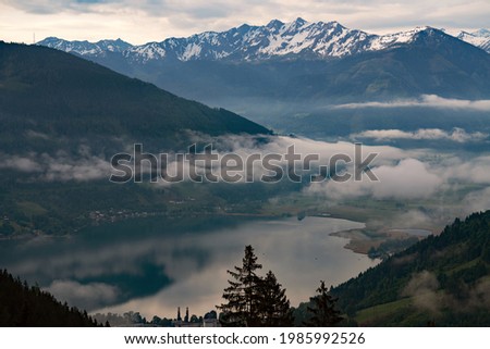 beautiful view of a lake and to the mountains on a foggy and cloudy morning in spring