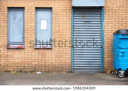 Shop front with blank sign and closed shutter door