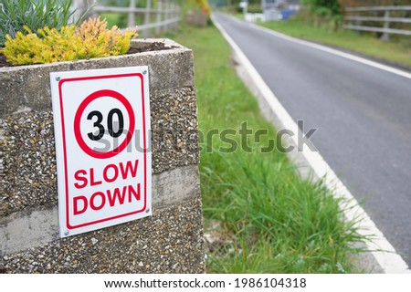 Slow down road sign at entrance to rural country village